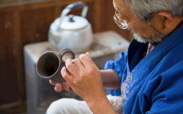 Local Japanese craftsman handcrafting traditional Hagi pottery in Hagi, Japan – showcasing centuries-old ceramic artistry in a historic castle town known for its unique clay ware and cultural heritage