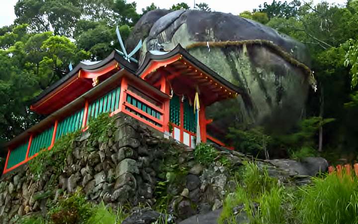 Steep stone staircase leading to Kamikura Shrine in Shingū, Wakayama, Japan, with the sacred Gotobiki rock perched on the mountainside and panoramic views of the Kumano region.