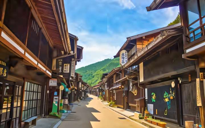 Scenic view of Narai-juku, a beautifully preserved Edo-period post town on the Nakasendo Trail in Japan—lined with traditional wooden buildings, historic inns, and shops against a mountain backdrop.