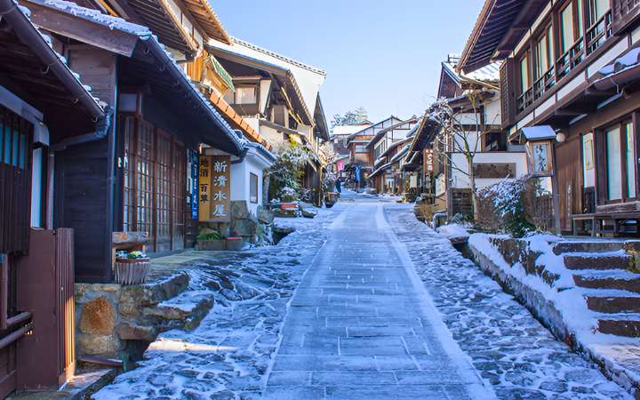 Snow-covered street in the historic post town of Tsumago-juku along the Nakasendo Trail, Japan – preserved Edo-period buildings and traditional charm in winter.