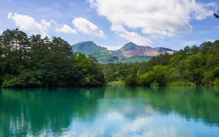 Bishamon-numa Pond, the largest of the Five Colored Ponds in Fukushima Japan, with vibrant blue-green water, mountain scenery, and popular hiking spot