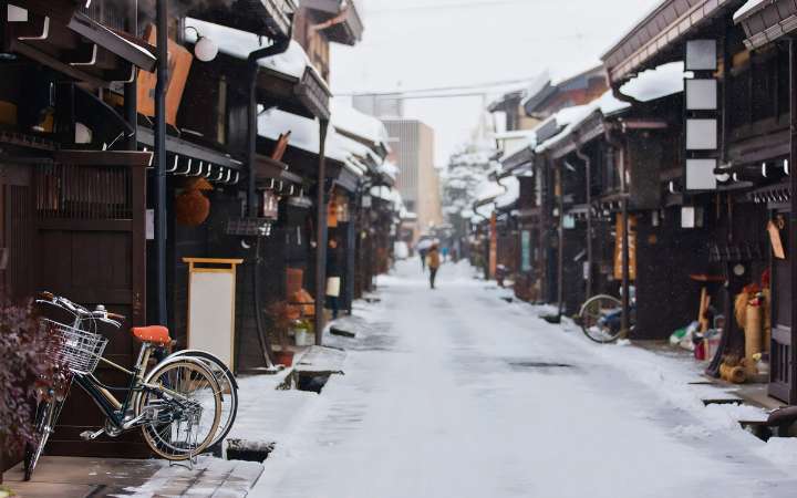 Snow-covered streets and traditional wooden houses in Takayama Old Town, Japan Alps