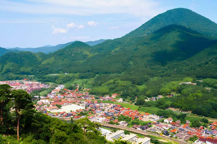 Panoramic view of the valley town of Tsuwano surrounded by lush mountains, seen from the Tsuwano Castle ruins during the 5-day San’in self-guided walking tour.