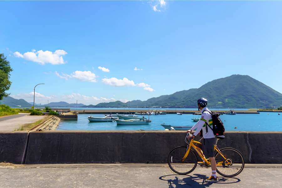A cyclist enjoys spectacular coastal scenery along the Shimanami Kaidō, Japan’s iconic cycling route linking Hiroshima and Ehime across the islands of the Seto Inland Sea.